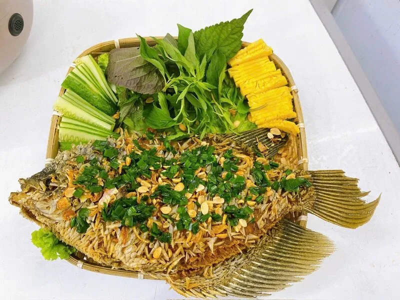 Cá tai tượng chiên xù được cuốn cùng bánh tráng, bún, rau sống và chấm nước mắm chua ngọt.